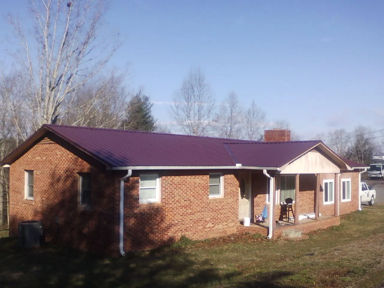 Burgundy metal roof on a brick ranch home with a new addition in Holland