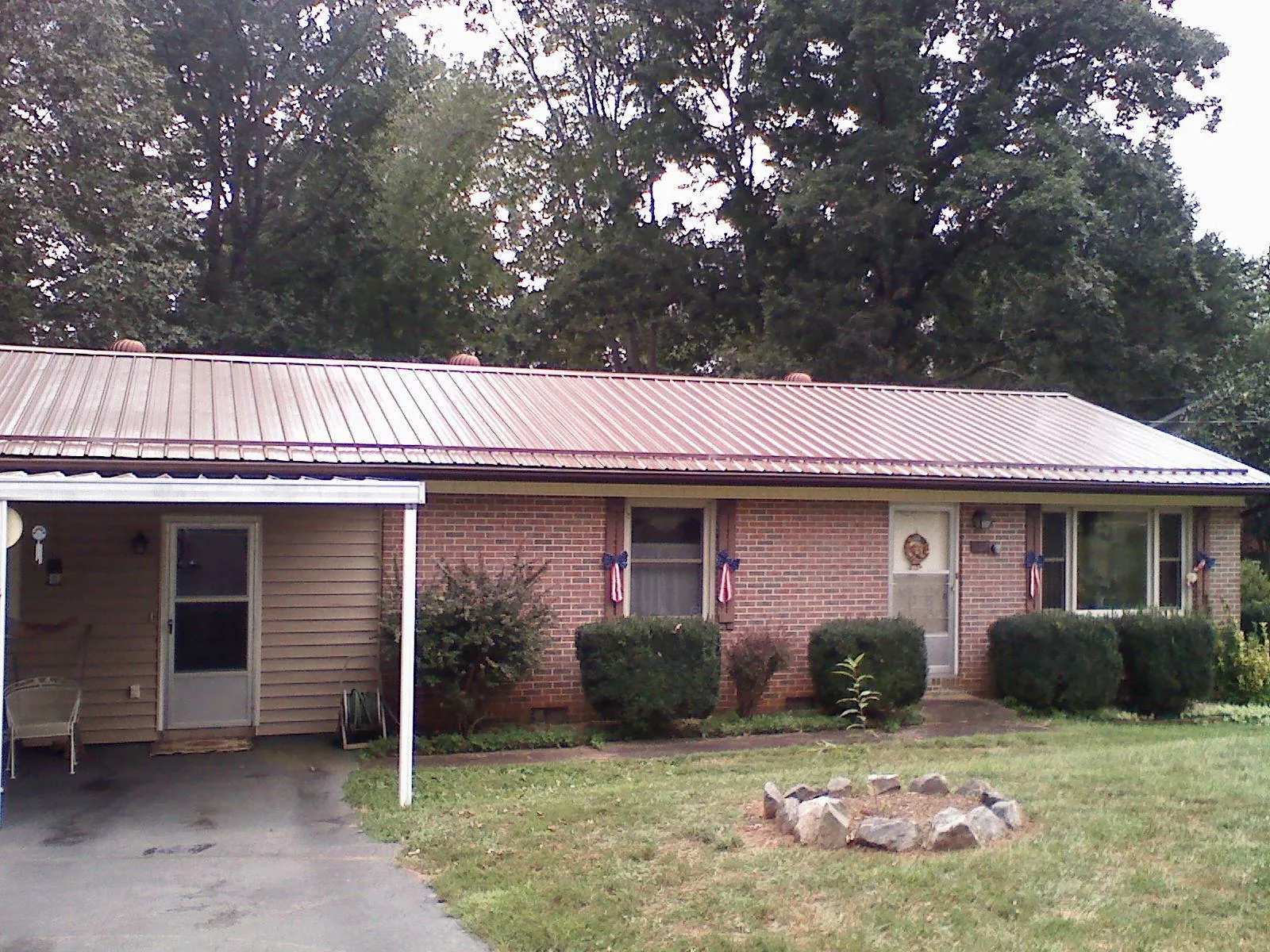 Bronze metal roof and carport on a brick ranch home — Roof Repair work by our crew in Holland